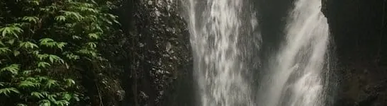 A jungle waterfall tumbling over a mossy cliff in Bali